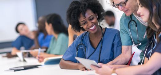 Senior female lecturer assists medical students during class stock photo